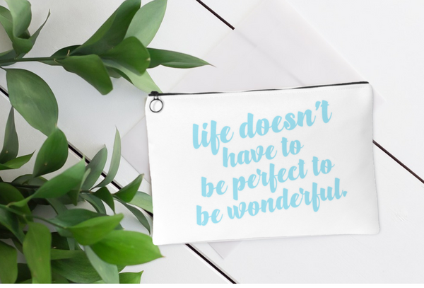 White accessory pouch. Blue lettering. Quote: Life Doesn't Have to be Perfect To Be Wonderful.